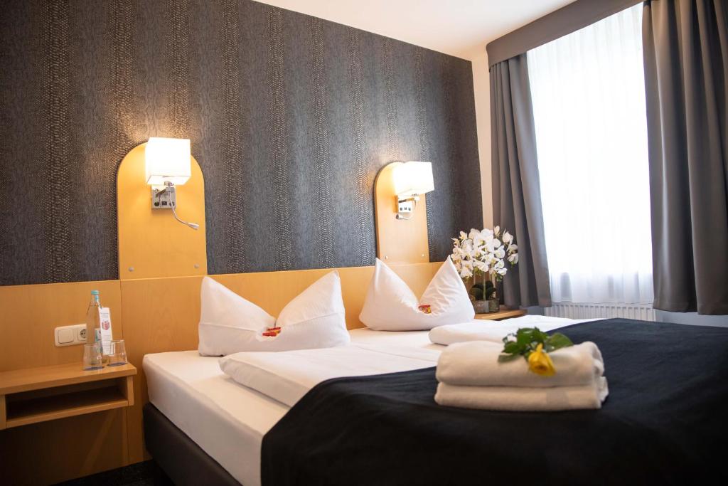 a hotel room with a bed with towels on it at Hotel Regina in Würzburg