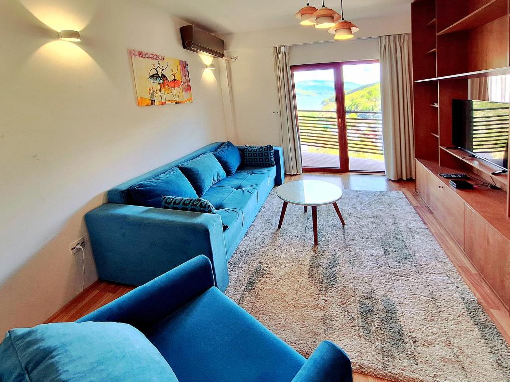 a living room with a blue couch and a table at Mavrovo Forest Apartments in Mavrovo