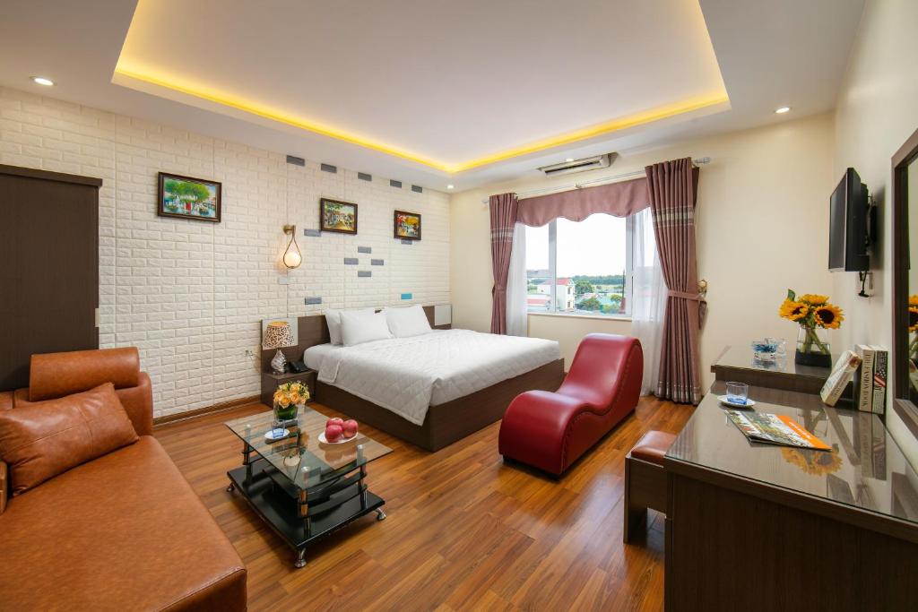 ein Wohnzimmer mit einem Bett und einem Sofa in der Unterkunft New Airport In & Suites in Hanoi