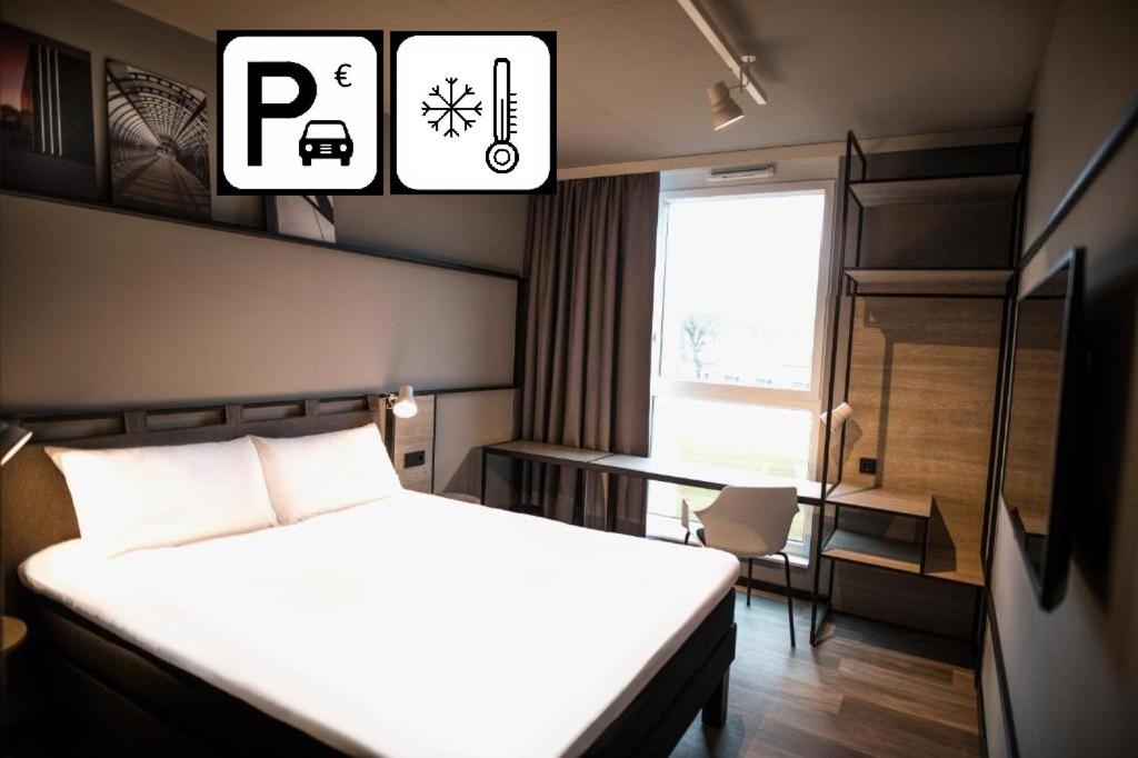 a bedroom with a bed and a table and a window at ibis Wels in Wels