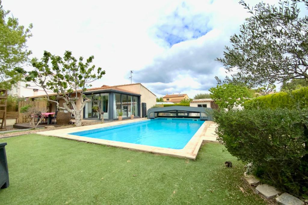 a swimming pool in the backyard of a house at The family villa with indoor swimming pool air conditioning and wooded gar in Teyran
