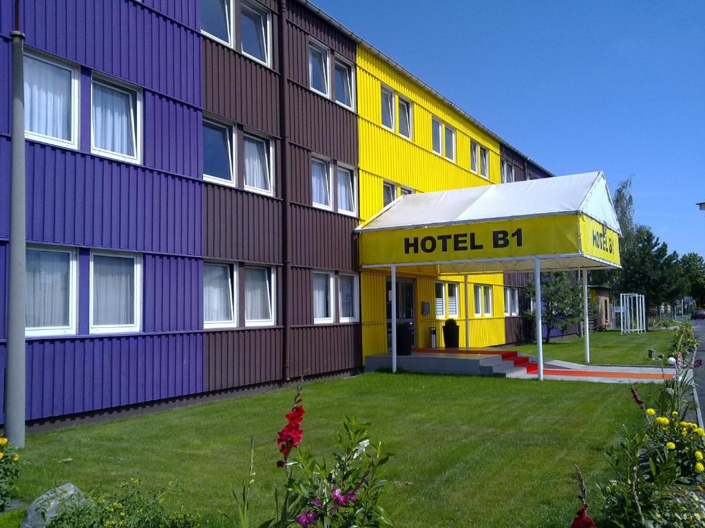 um edifício de hotel com uma fachada amarela e roxa em Hotel B1 em Berlim