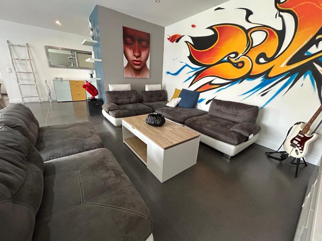 a living room with two couches and a table at Maison 120m, jardin, parking, piscine in Sainte-Cécile-les-Vignes