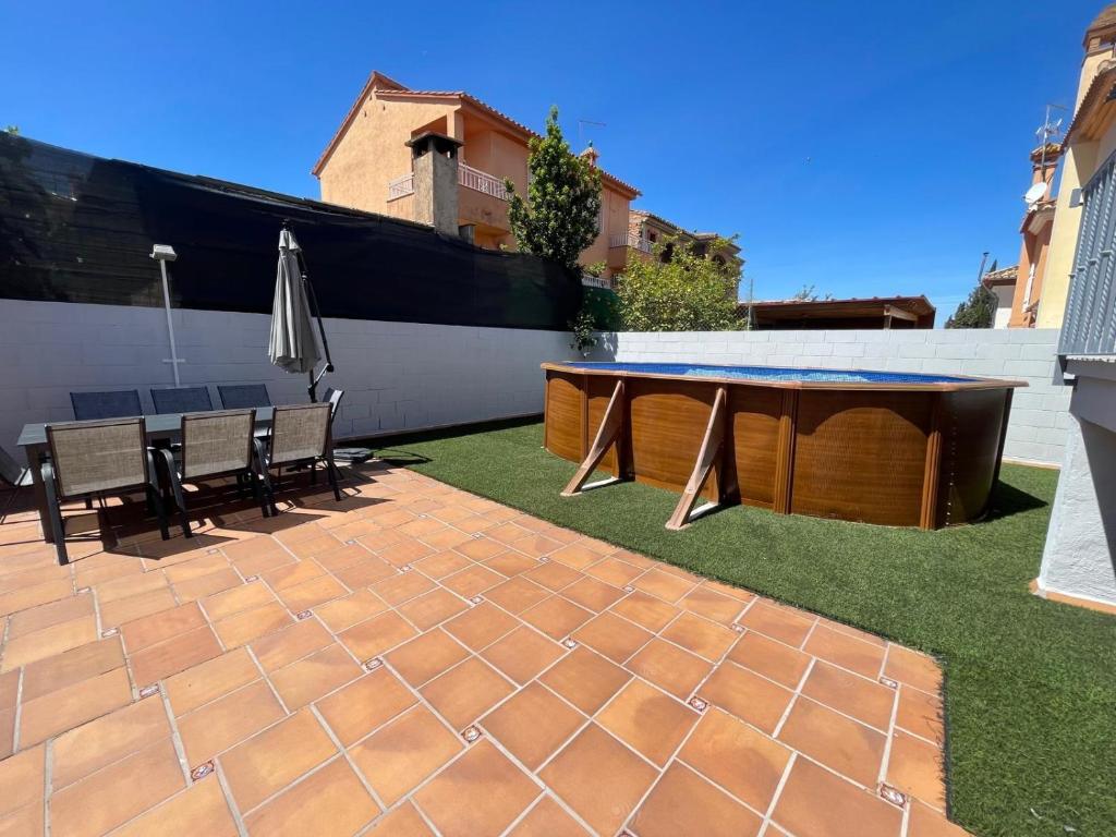 eine Terrasse mit einem Tisch, Stühlen und einem Sonnenschirm in der Unterkunft CASA FAMILIAR LA ZUBIA - Granada in La Zubia