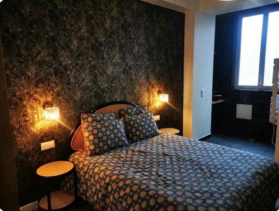1 dormitorio con 1 cama con 2 mesas y 2 lámparas en Le moderne 100 mètres de la gare parking gratuit, en Douai