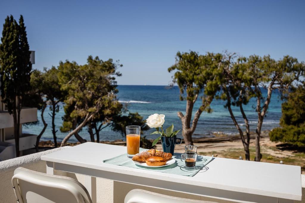 Attico Margherita - LA TERRAZZA SUL MARE في غالّيبولي: طاولة مع طبق من المواد الغذائية والمشروبات على الشاطئ