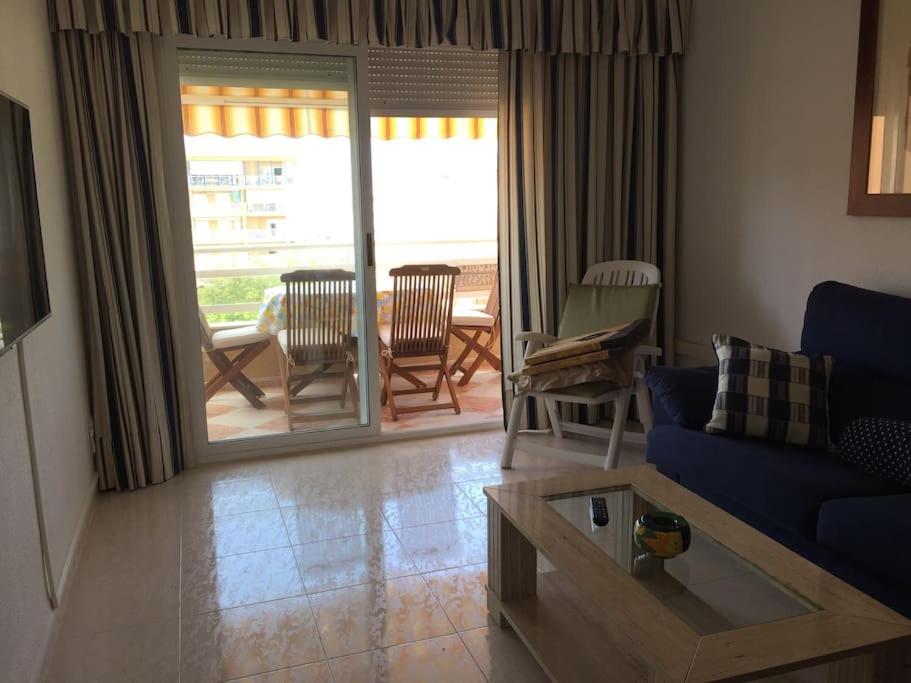 ein Wohnzimmer mit einem blauen Sofa und einem Tisch in der Unterkunft Apartamento acogedor playa Miramar in Miramar