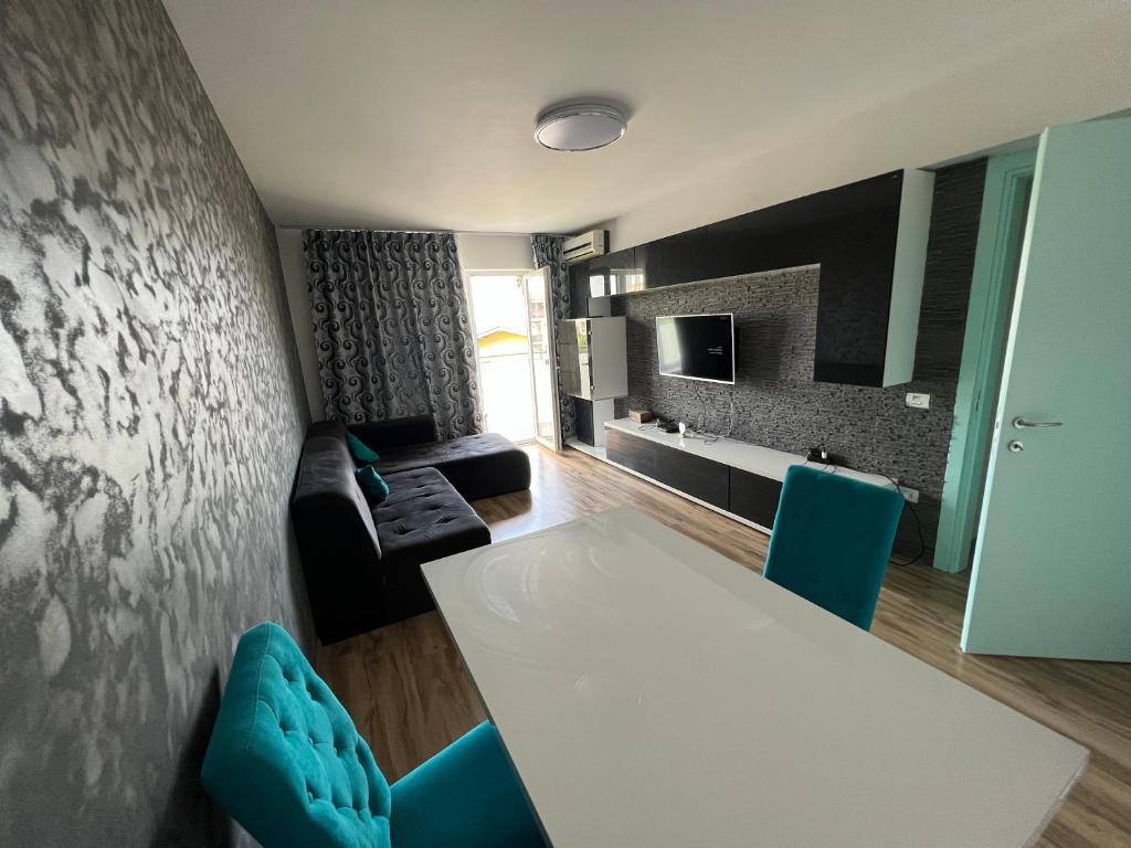 ein Wohnzimmer mit einem weißen Tisch und blauen Stühlen in der Unterkunft Apartament Queen in Oradea