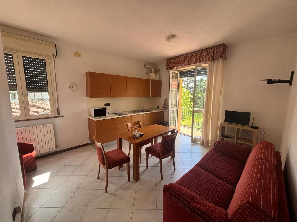 uma sala de estar com um sofá, uma mesa e uma cozinha em Il Rampicante-Monticelli Terme em Monticelli Terme