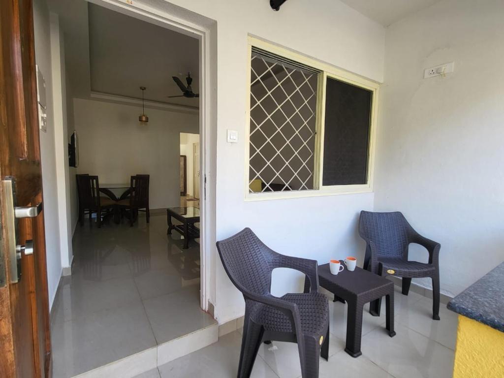 a room with chairs and a table and a window at Palm Crest The Colva Diaries in Colva