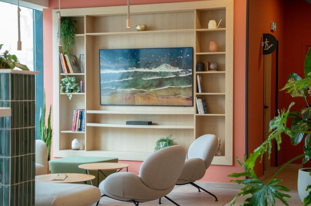 - un salon avec deux chaises et une télévision dans l'établissement Kyriad Marseille Palais Des Congrès – Vélodrome, à Marseille