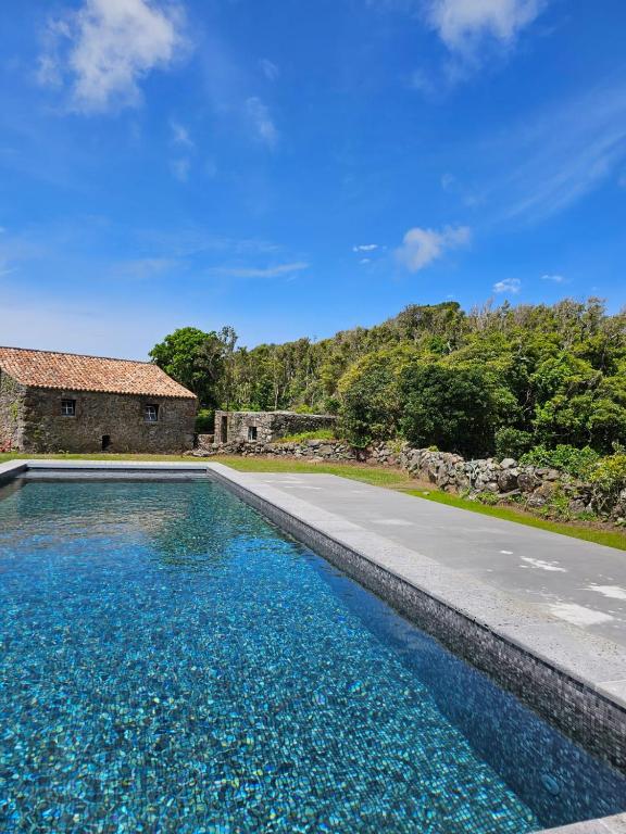 a swimming pool in front of a house at Aldeia da Cuada in Faja Grande