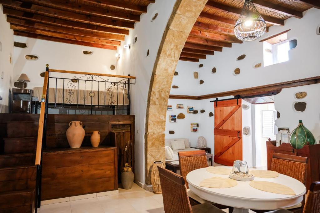 uma sala de jantar com uma mesa branca e cadeiras em Anesis Traditional Rhodian House em Kattavía