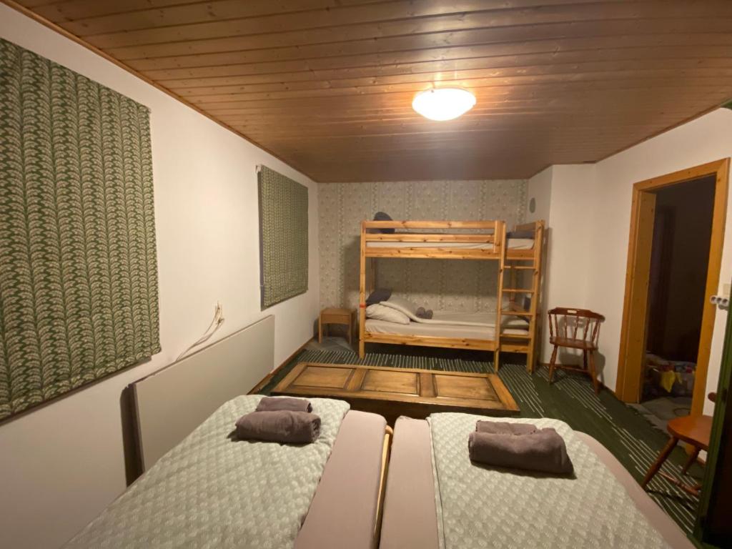 ケヒダクスタニーにあるGinkgo Houseのベッド2台と二段ベッド1組が備わる客室です。