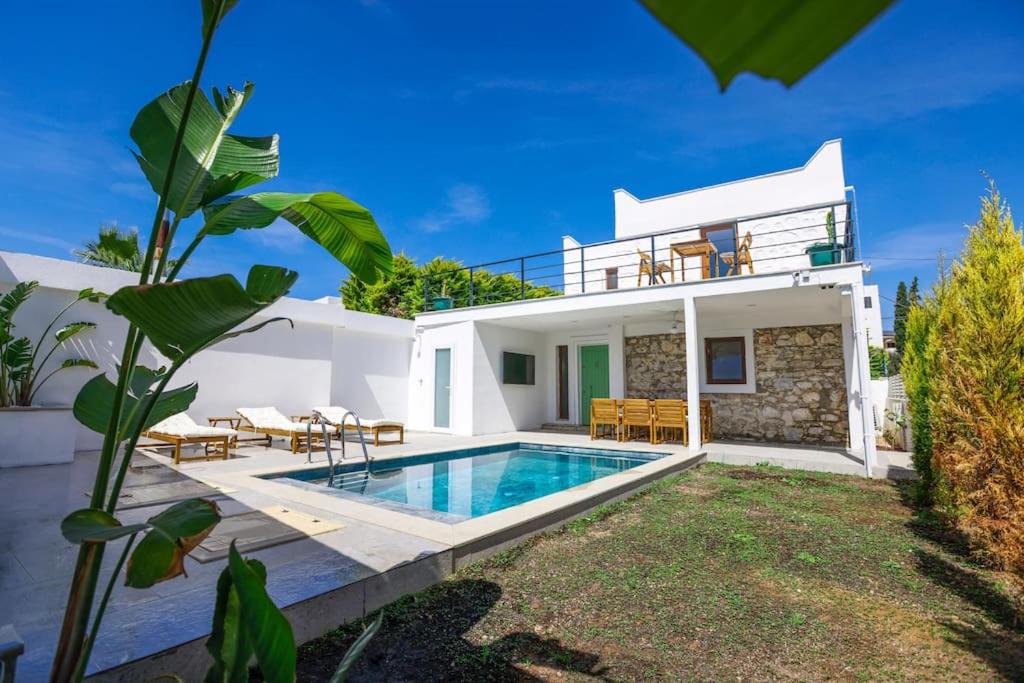 una villa con piscina di fronte a una casa di Traditional Seaside Stone Villa with Private Pool a Bodrum City