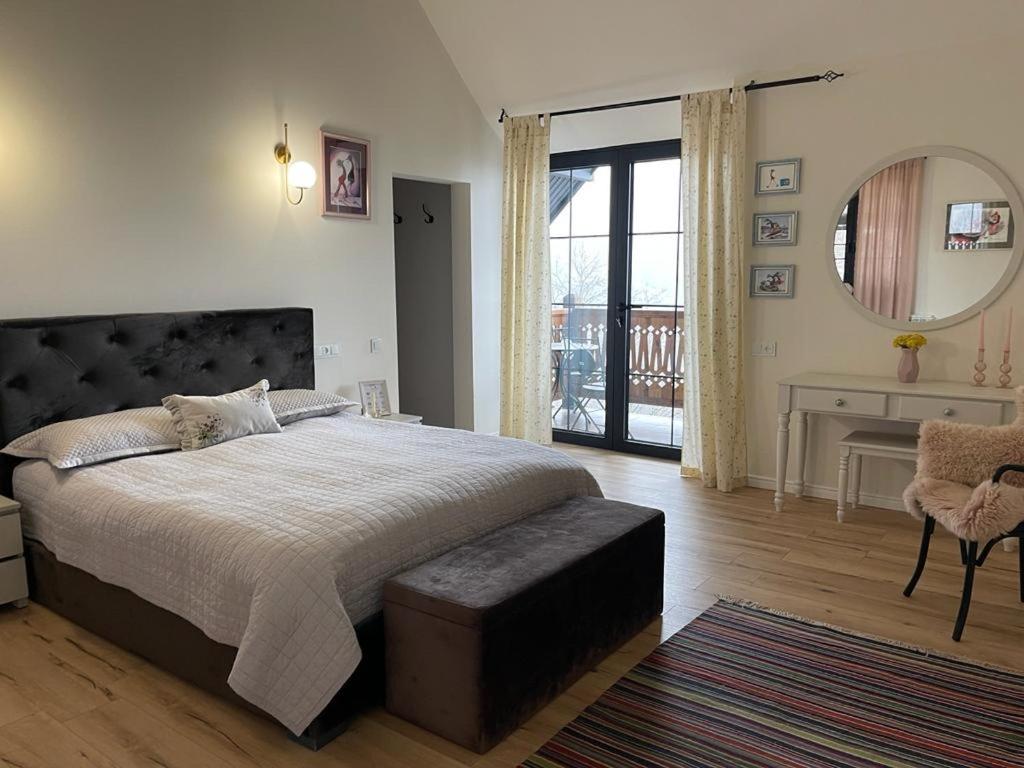 1 dormitorio con 1 cama grande y espejo en Balkonum Luxury Guest House, en Gosh