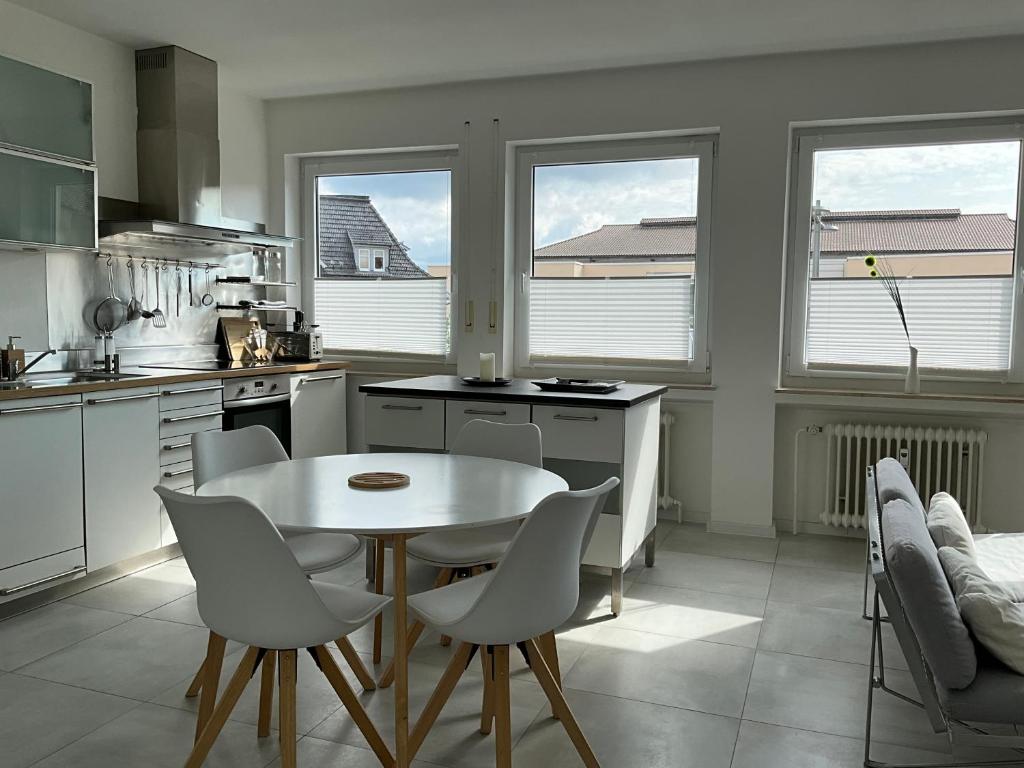 een keuken met een witte tafel en stoelen. bij City Loft in Freudenstadt