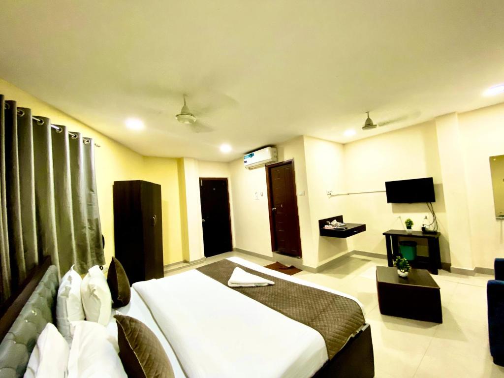 a hotel room with a bed and a television at Hotel Sky Park in Shamshabad