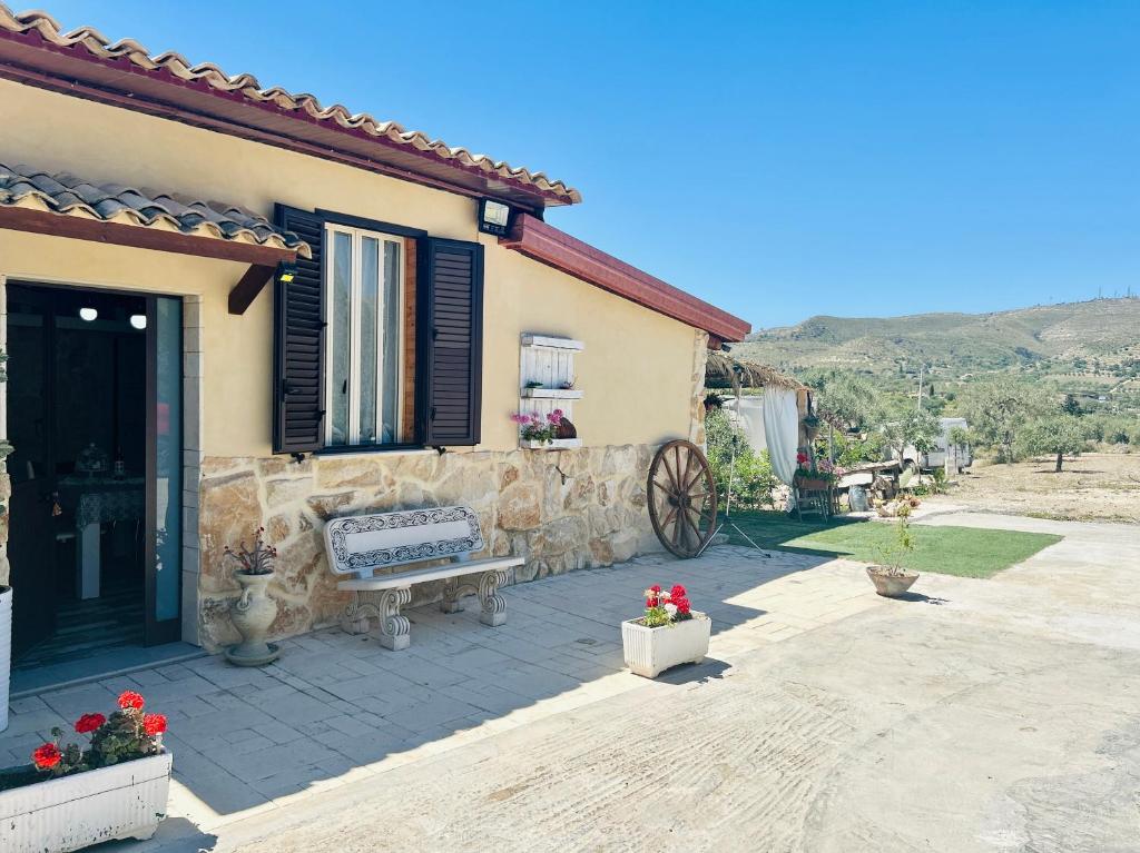 a house with a bench in front of it at "The Cottage"with sea view, parking & wifi in Avola