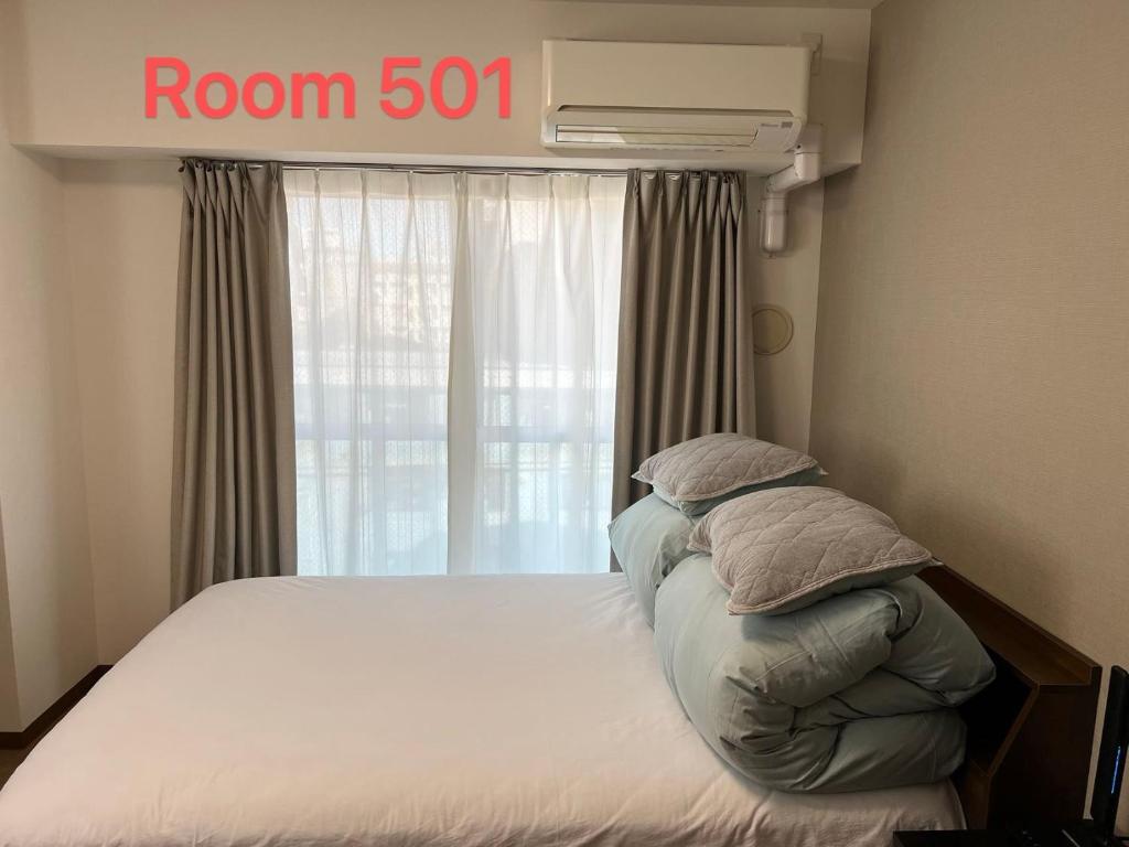 um quarto com uma cama com uma placa de quarto por cima em SkyHotel Ryogoku 駅徒歩4分 em Tóquio