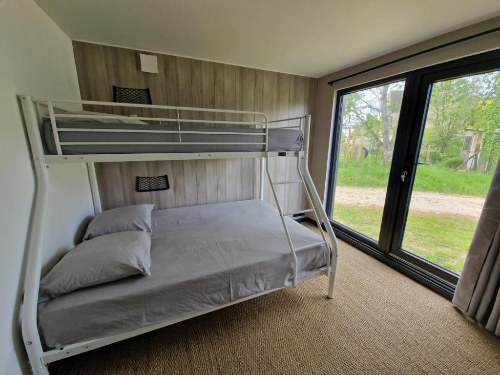 Etagenbett in einem Zimmer mit Fenster in der Unterkunft Chalets des prés-village in Bussy-le Repos