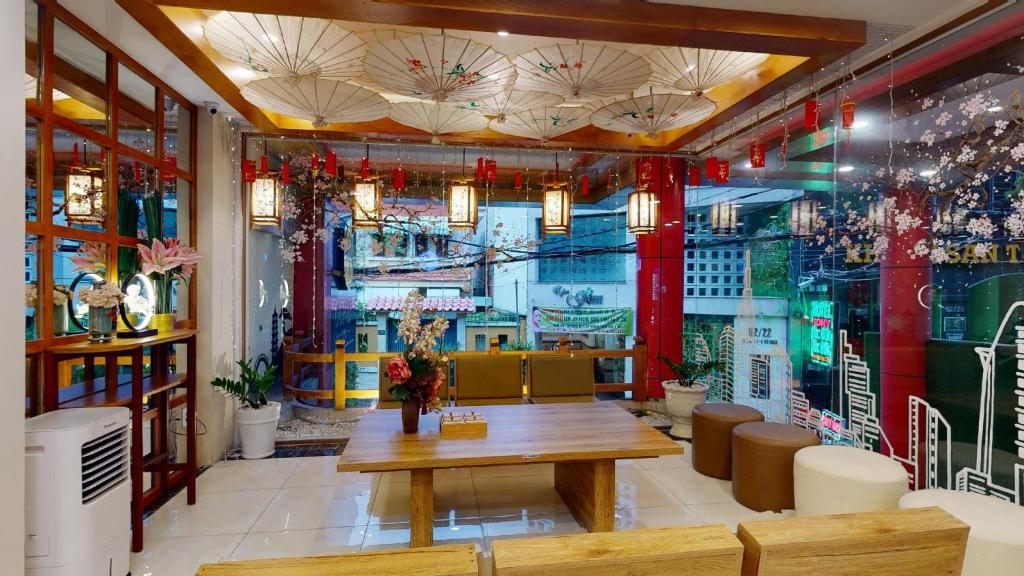 um restaurante com uma mesa e cadeiras e uma janela em Cupid Hotel 2 em Ho Chi Minh