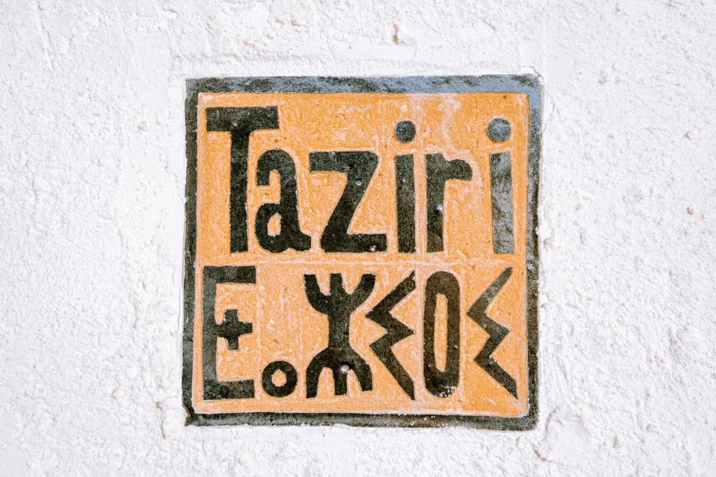 a sign on the side of a wall with graffiti at Villa Madame Babouche, chambre Taziri, SdB privative in Oulad el Madani