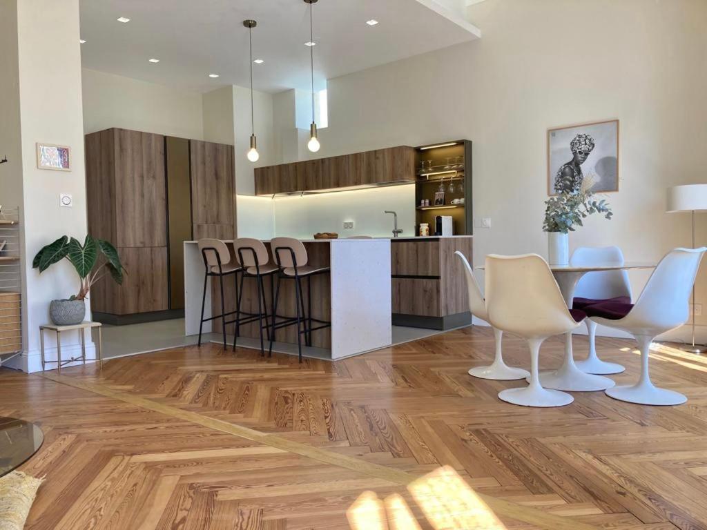 une cuisine avec une table et des chaises dans une pièce dans l'établissement Palais Massenet -Exceptionnel 50m de la mer, à Nice