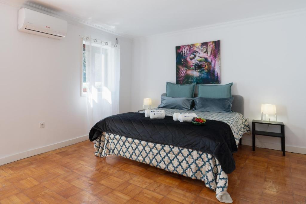 1 dormitorio con 1 cama con una pintura en la pared en Maria Pia Suite 4 com Terraço, en Oporto