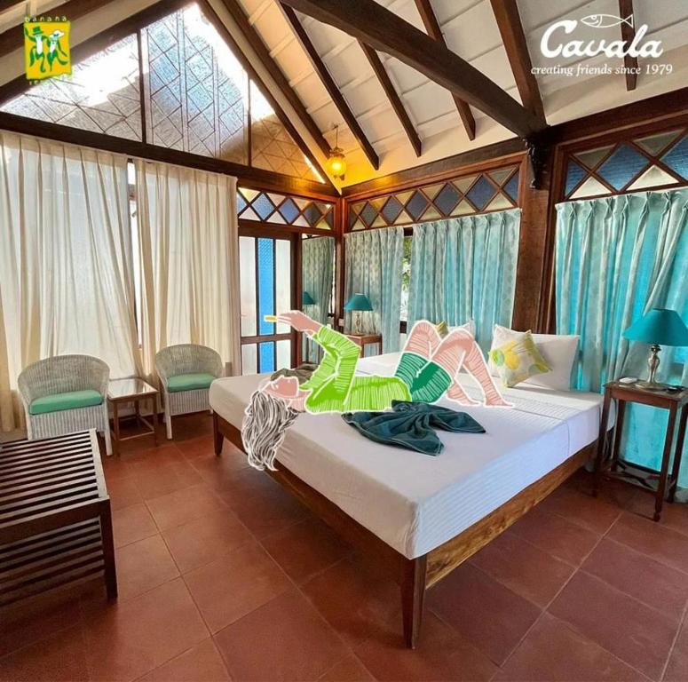 een slaapkamer met een bed waar een persoon op ligt bij Cavala The Seaside Resort in Baga