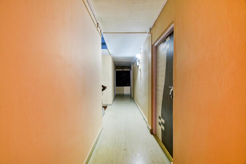 a hallway with an orange wall and a long corridor at Ekora Resort in Hatikhuli