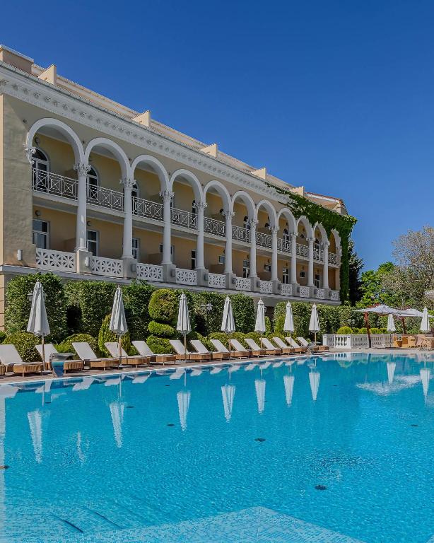 a hotel with a large swimming pool with chairs and umbrellas at Palace Del Mar in Odesa