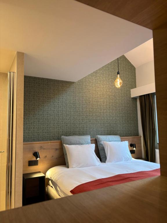 1 dormitorio con 1 cama grande y 2 almohadas blancas en B&B Les Oiseaux de Passage, en Harre