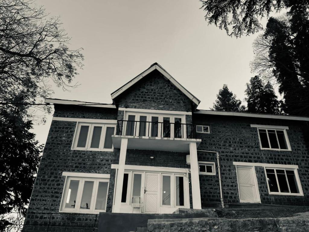uma foto a preto e branco de uma casa de tijolos em Vintage Hut Dunga Gali em Abbottabad