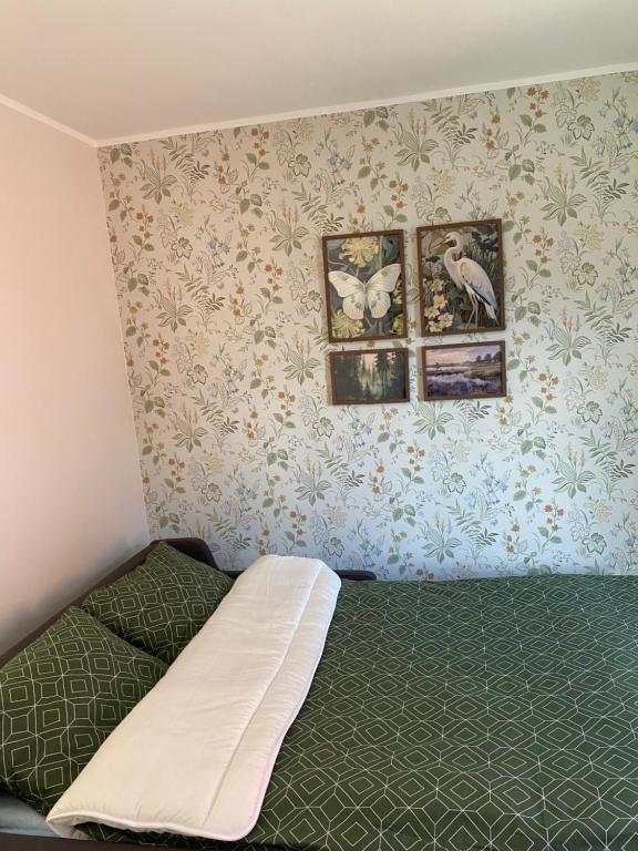 a bedroom with a bed and two pictures on the wall at City centre one room apartment in Tartu