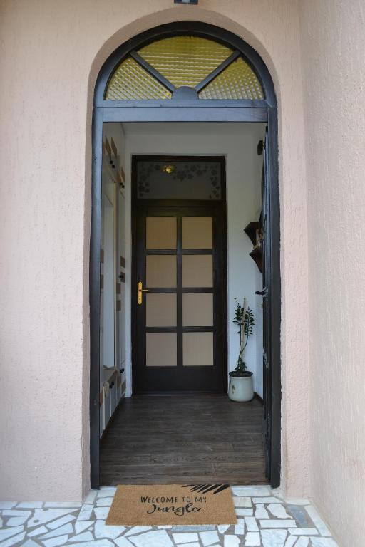 una porta con un tappetino di benvenuto davanti di Apartman Gluhović a Sombor