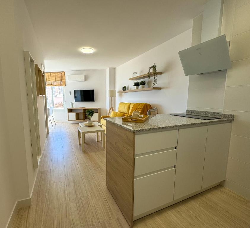 uma cozinha com um balcão e uma sala de estar em Apartment Avril by Spain2home em Torrox Costa