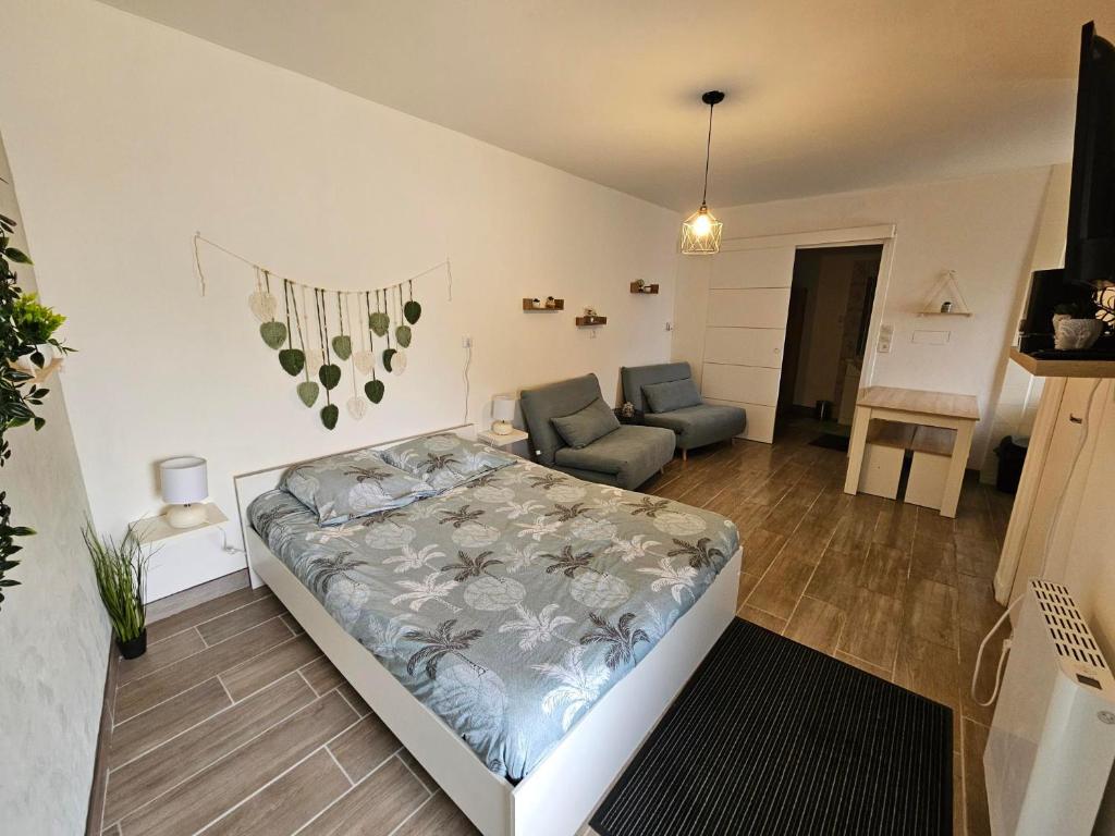 ein Schlafzimmer mit einem Bett, einem Sofa und einem Stuhl in der Unterkunft Maisonnette du Relais de Vauchamps 