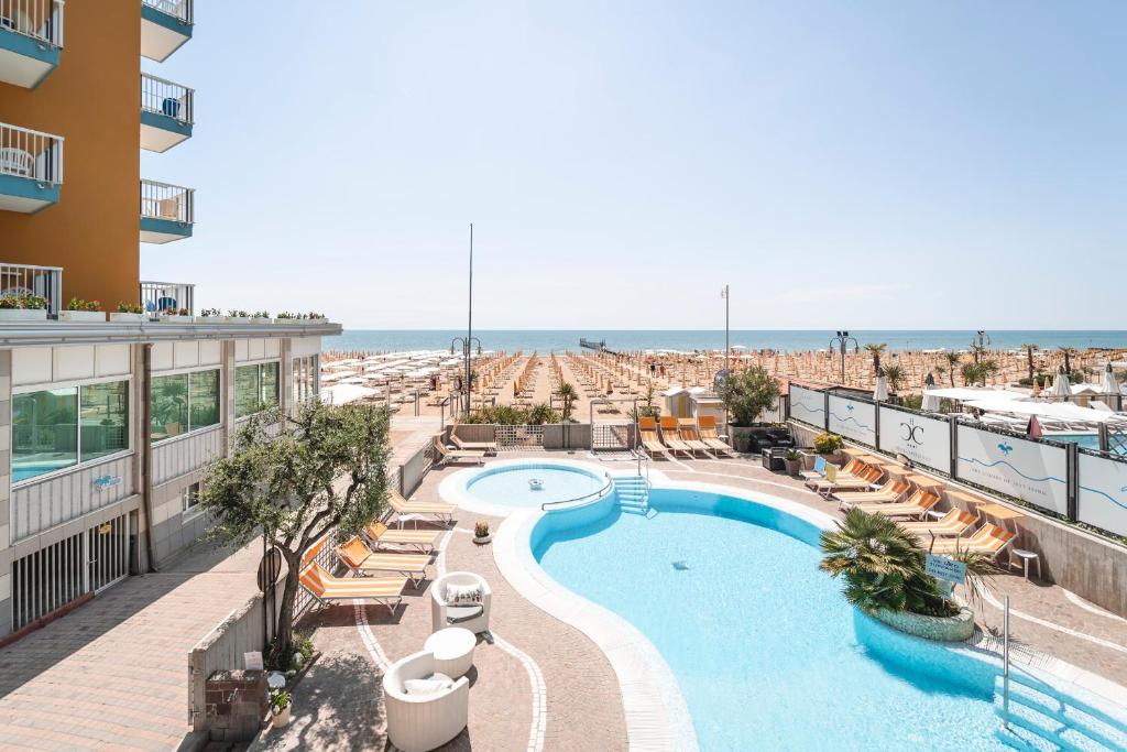 una imagen de una piscina en un complejo en Hotel Capri 3 Stelle SUPERIOR, en Lido di Jesolo