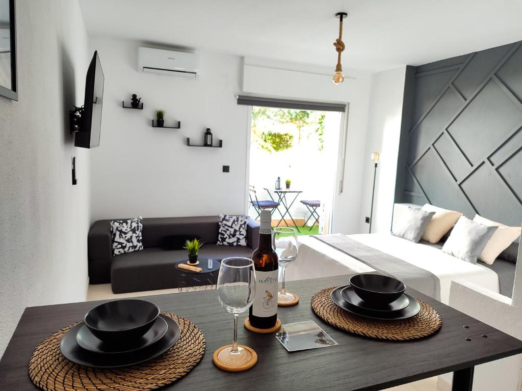 een woonkamer met een tafel met hoeden en wijnglazen bij Rota Candor Apartamento in Rota