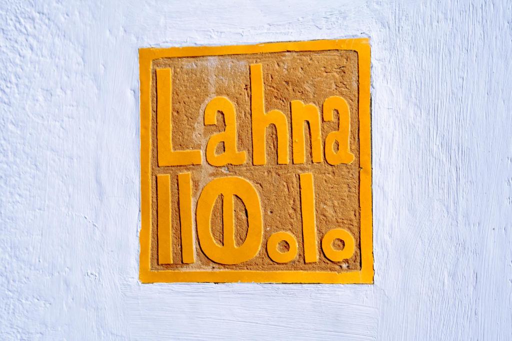 a yellow sign on a white wall with the word larmaonga at Villa Madame Babouche, Studio Lahna, SdB privative in Oulad el Madani