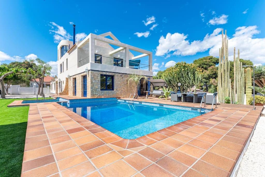 a home with a swimming pool in front of a house at Villa Lucentum in Alicante