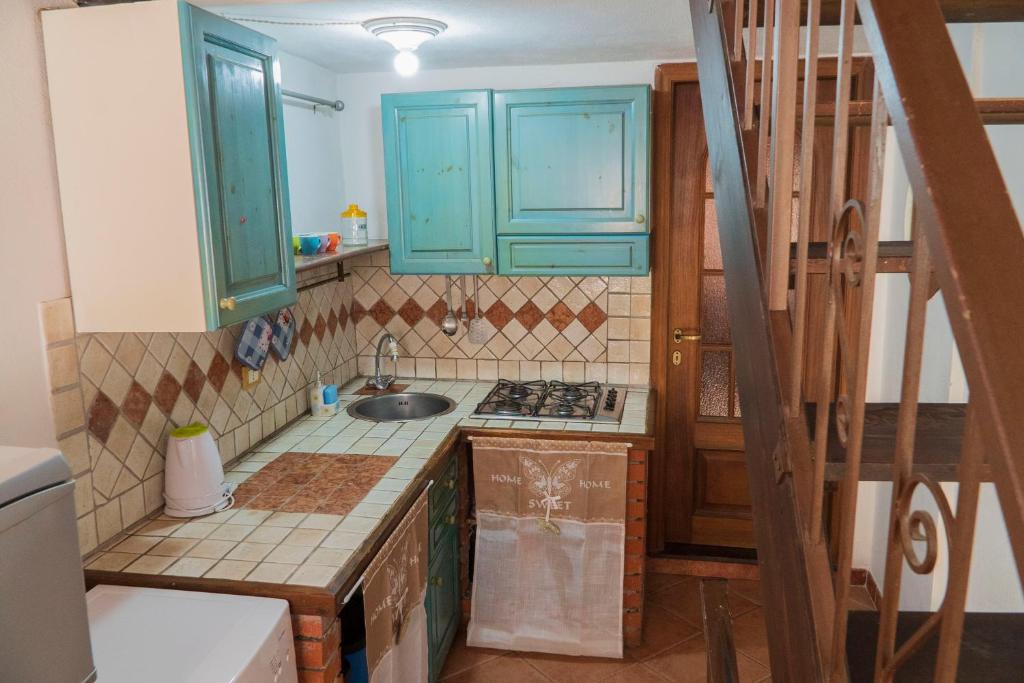a kitchen with blue cabinets and a sink at Maria Guesthouse in Sassari