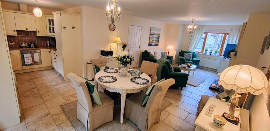 eine Küche und ein Wohnzimmer mit einem Tisch und Stühlen in der Unterkunft Lough Rynn in Mohill