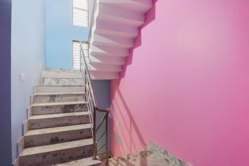 a stairway with a pink wall and pink stairs at OYO Maa Home Stays 5 in Bhubaneshwar