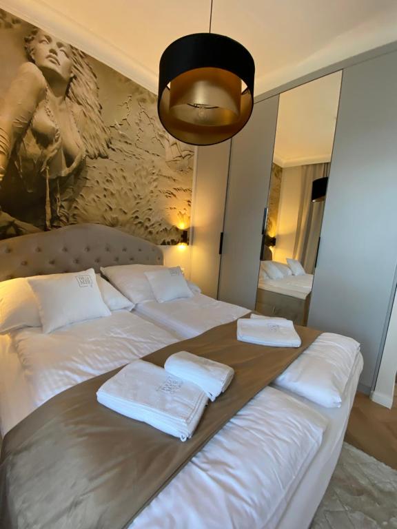 a large bed with white sheets and towels on it at Niechorze - Par La Mer 6B in Niechorze