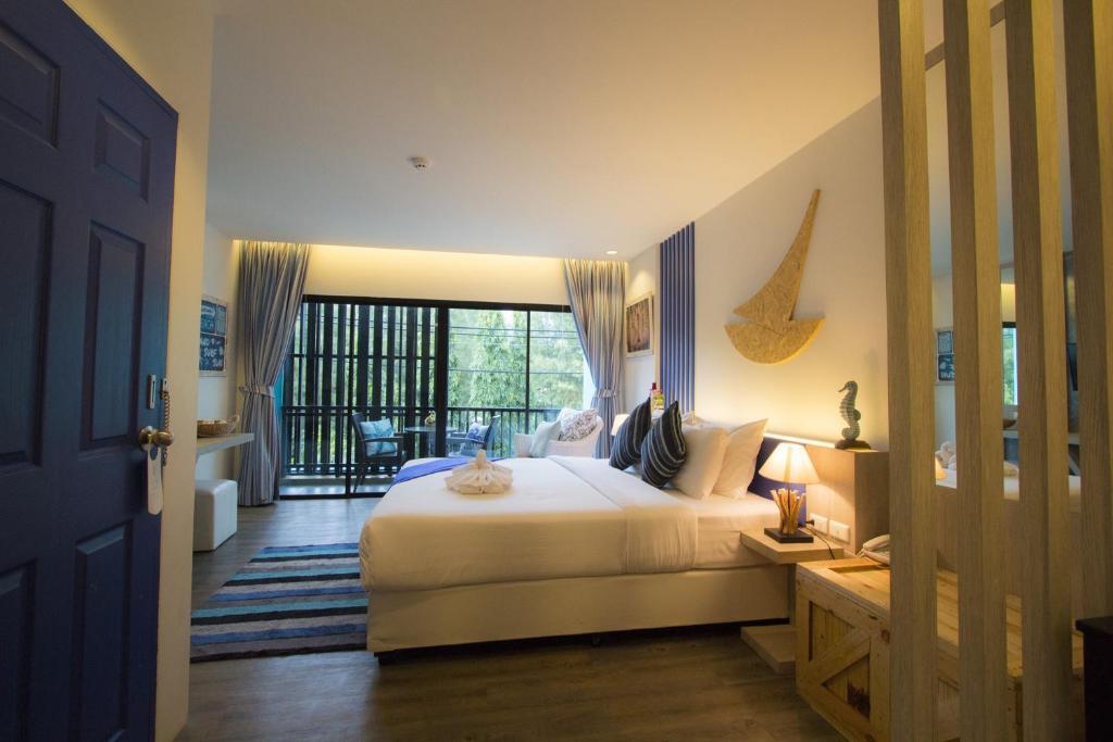 1 dormitorio con 1 cama y balcón en The Blue Pearl Kata Hotel, en Kata Beach