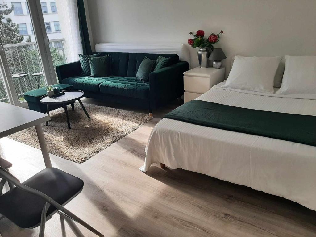 um quarto com uma cama verde e um sofá em Magnifique Studio de 25 m2 em Paris