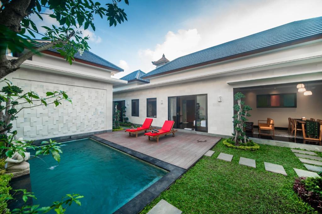a backyard with a swimming pool and a house at Gaing Mas Jimbaran Villas by Gaing Mas Group in Jimbaran
