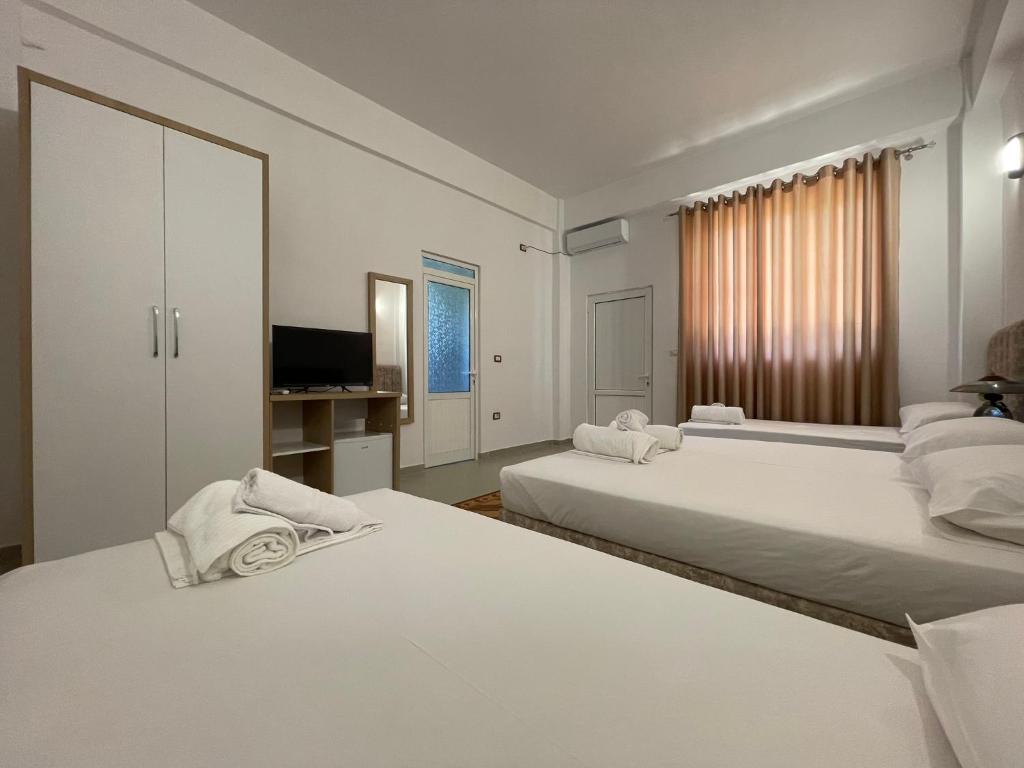 two white beds in a room with a television at Villa Deart Berat in Berat